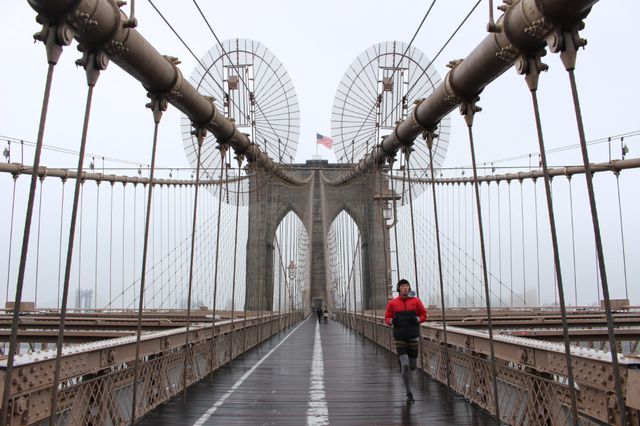 A photo of a man running on the Brooklyn Bridge